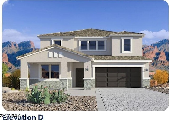 view of front facade with decorative driveway, stone siding, a mountain view, and stucco siding