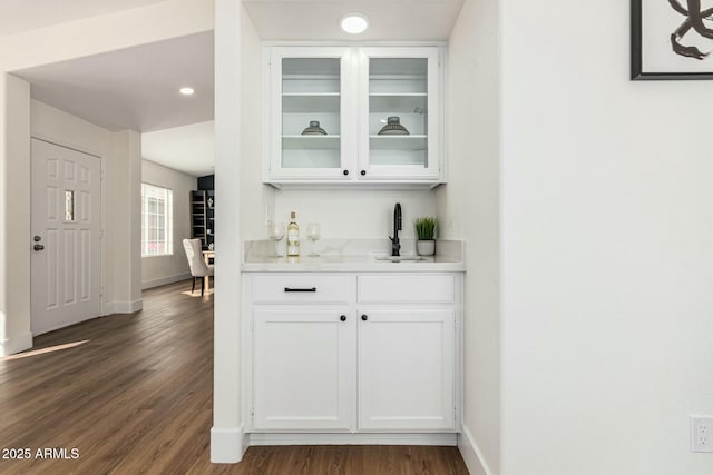 bar featuring white cabinets, sink, and dark wood-type flooring