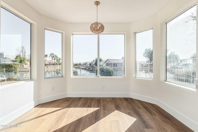 unfurnished sunroom featuring a healthy amount of sunlight and a water view