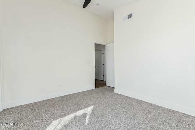 carpeted spare room featuring a high ceiling and ceiling fan