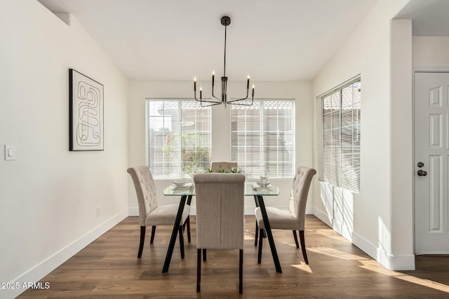 dining area with a notable chandelier, dark hardwood / wood-style flooring, and plenty of natural light