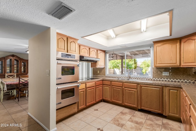 kitchen featuring black electric stovetop, sink, ceiling fan, double oven, and tasteful backsplash