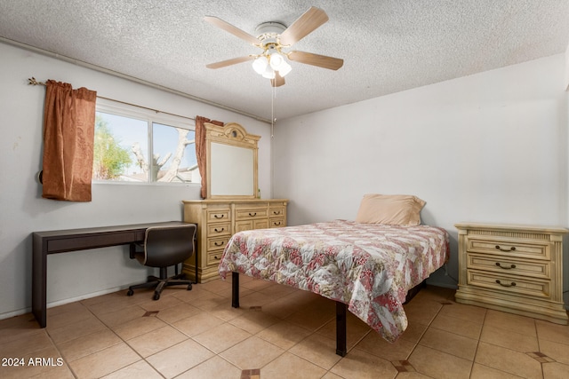 bedroom with a textured ceiling, ceiling fan, and light tile patterned flooring