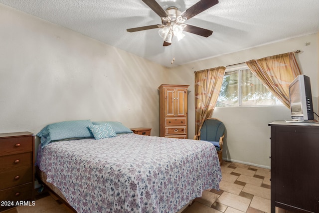 bedroom featuring ceiling fan and a textured ceiling