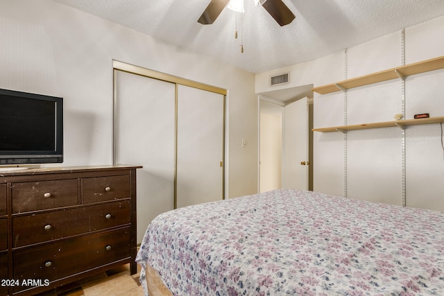 bedroom with a textured ceiling, a closet, and ceiling fan