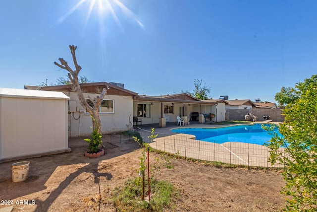 view of pool with a patio and a storage unit