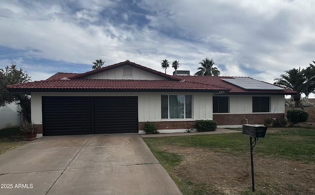 4353 W Mescal St, Glendale, AZ 85304 - ranch-style home featuring driveway, brick siding, a garage, solar panels, and board and batten siding