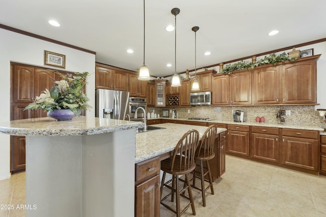 kitchen with sink, appliances with stainless steel finishes, a kitchen island with sink, tasteful backsplash, and decorative light fixtures