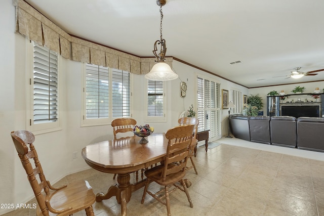 dining space featuring crown molding and ceiling fan