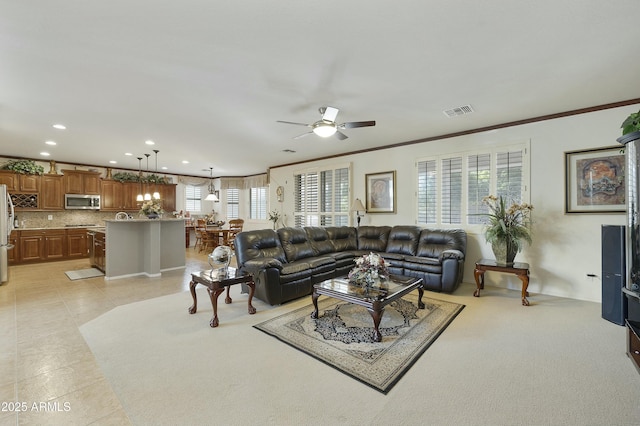 living room featuring ornamental molding, light tile patterned flooring, and ceiling fan