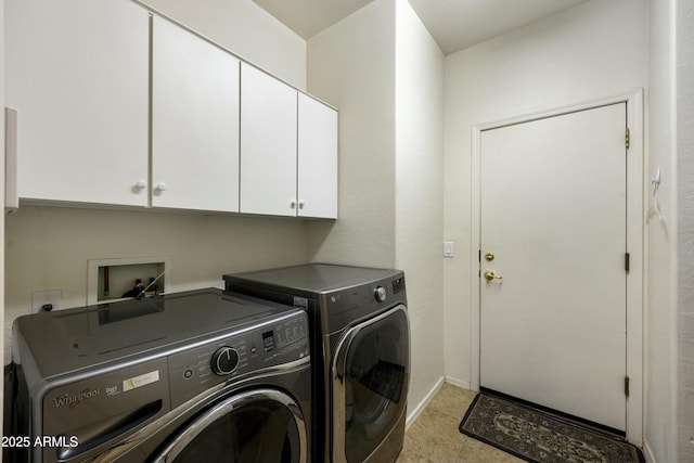 clothes washing area featuring independent washer and dryer and cabinets