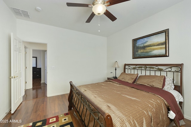 bedroom with dark hardwood / wood-style floors and ceiling fan