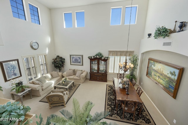 living room with carpet flooring, an inviting chandelier, and a towering ceiling