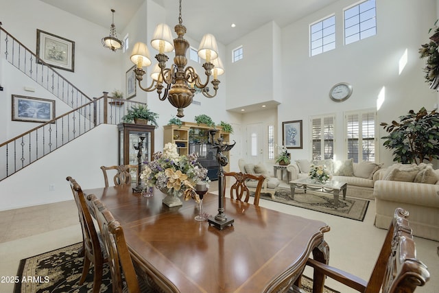 tiled dining space featuring a towering ceiling and a chandelier