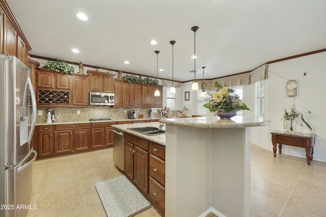 kitchen featuring sink, light stone counters, decorative light fixtures, appliances with stainless steel finishes, and a kitchen island with sink