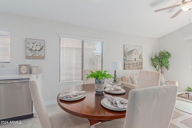 tiled dining space featuring ceiling fan and lofted ceiling