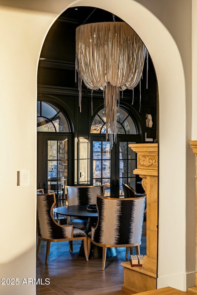 dining room featuring arched walkways and wood finished floors