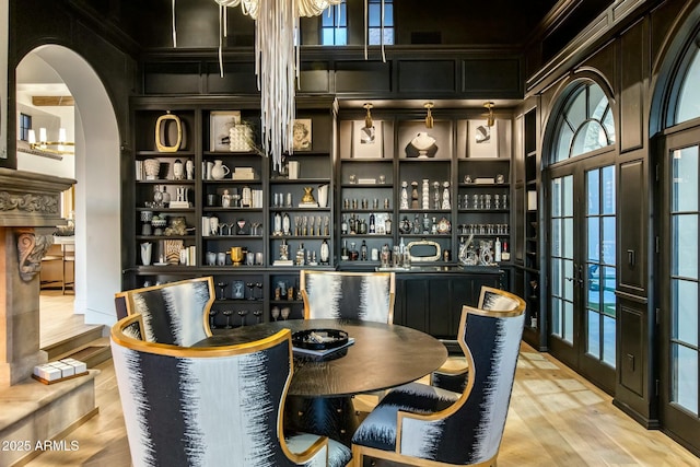 interior space featuring a community bar, arched walkways, and wood finished floors