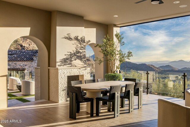 view of patio / terrace with outdoor dining area, an outdoor bar, ceiling fan, and a deck with mountain view