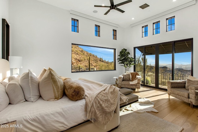 bedroom featuring access to outside, recessed lighting, a high ceiling, a mountain view, and light wood-type flooring