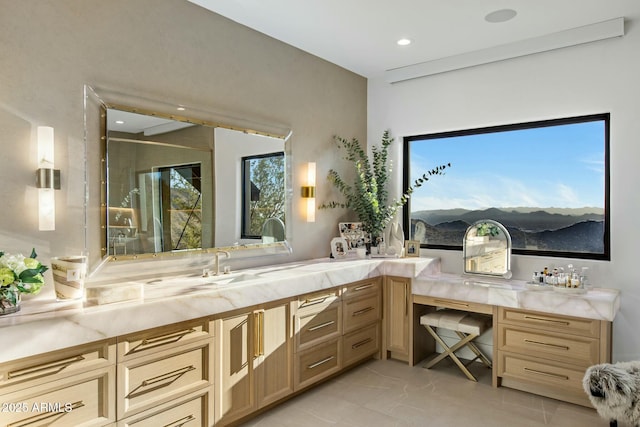 bathroom featuring double vanity, marble finish floor, a mountain view, a sink, and recessed lighting