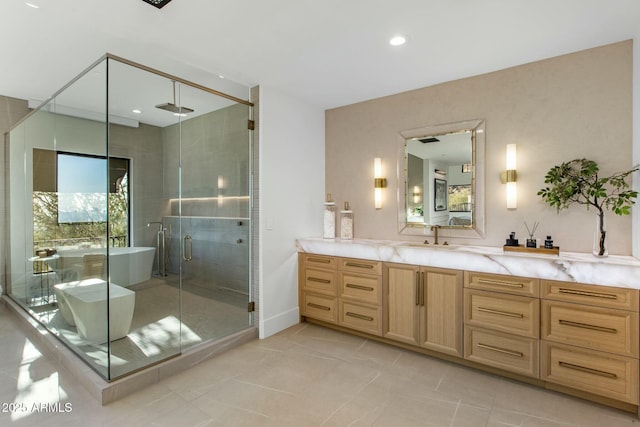 full bathroom with vanity, a freestanding tub, a shower stall, and a wealth of natural light