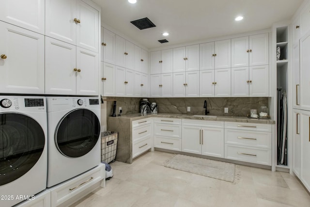 washroom with recessed lighting, cabinet space, visible vents, washing machine and dryer, and a sink