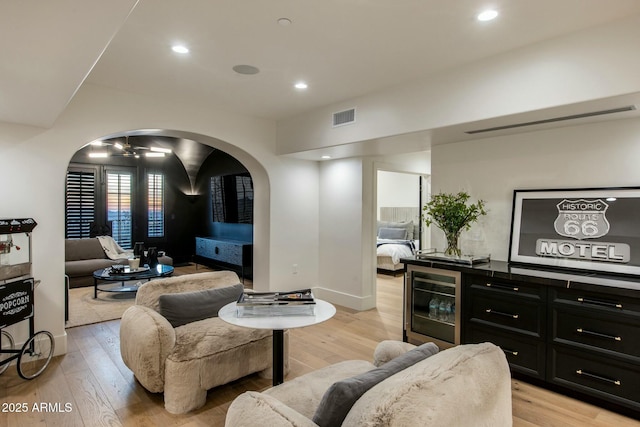 living area featuring light wood-type flooring, visible vents, recessed lighting, and wine cooler
