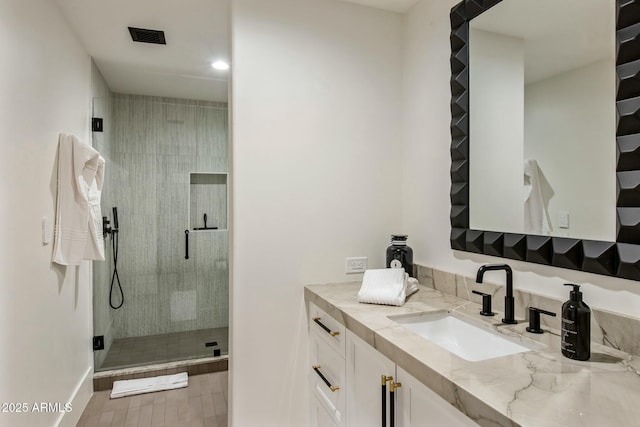 bathroom featuring a shower stall and vanity