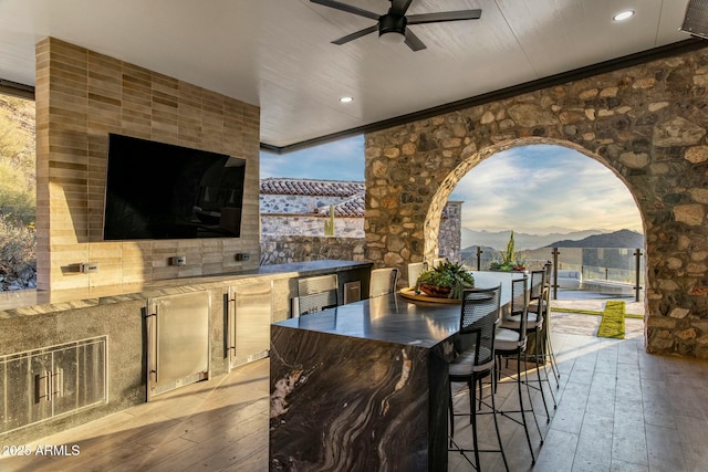 view of patio featuring exterior kitchen, a ceiling fan, and outdoor wet bar