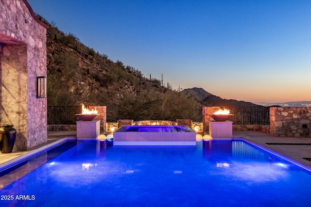 view of swimming pool with a jacuzzi and a mountain view