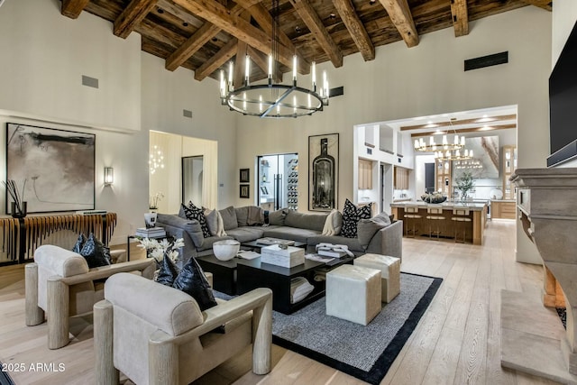 living room with light wood-style floors, wood ceiling, a chandelier, and beamed ceiling