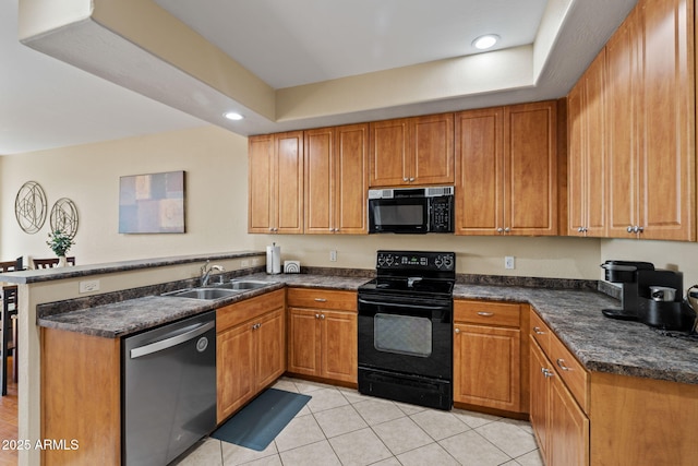 kitchen with brown cabinetry, a peninsula, recessed lighting, a sink, and black appliances