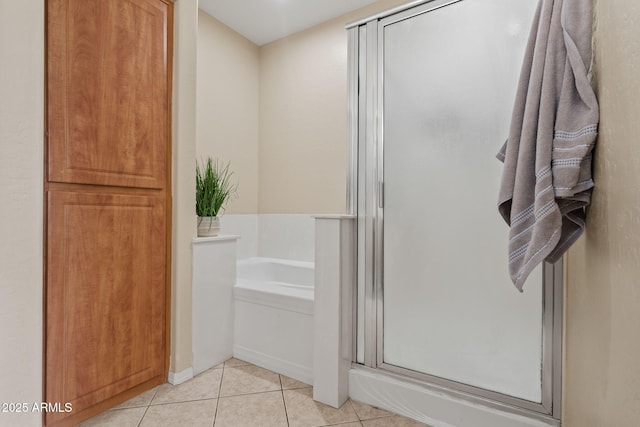 full bath with tile patterned flooring, a stall shower, and a garden tub