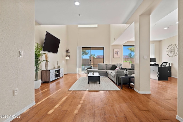 living room with recessed lighting, baseboards, and hardwood / wood-style floors