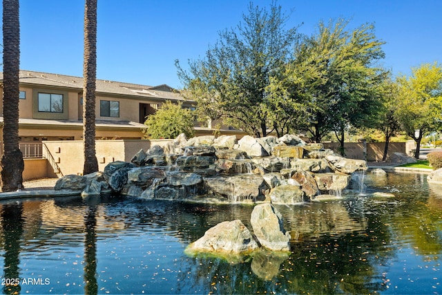 exterior space featuring a garden pond and fence