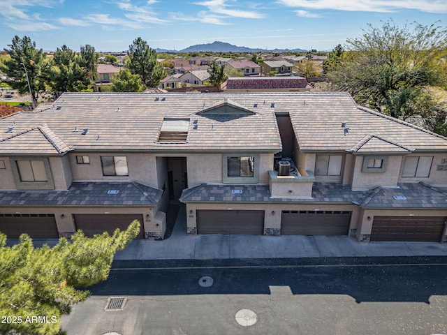 view of front of home featuring a mountain view, stucco siding, an attached garage, and driveway