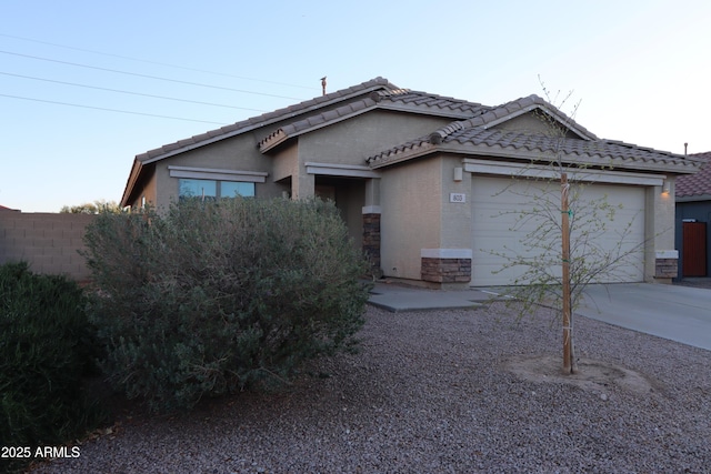 single story home featuring fence, concrete driveway, stucco siding, a tile roof, and a garage
