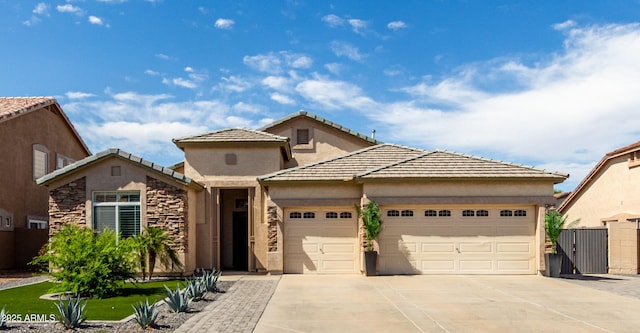 view of front of house featuring fence, an attached garage, a tile roof, stucco siding, and concrete driveway
