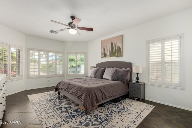 bedroom with dark tile patterned flooring, baseboards, ceiling fan, and visible vents