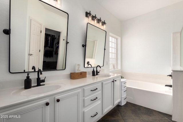 full bathroom with a sink, tile patterned flooring, a garden tub, and double vanity