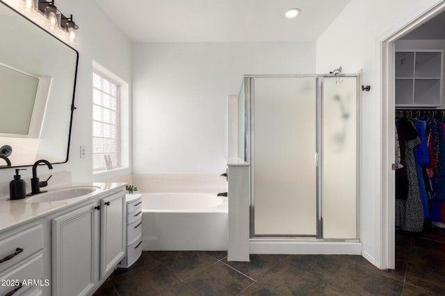 full bathroom with a walk in closet, vanity, recessed lighting, a shower stall, and a bath