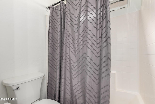 bathroom with toilet and a shower with curtain