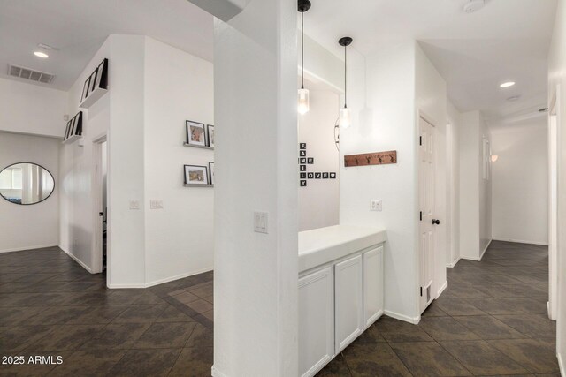 hall with stone finish flooring, baseboards, visible vents, and recessed lighting