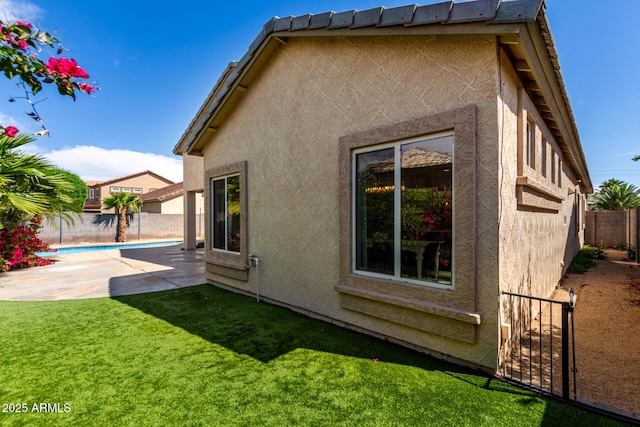 back of property with a fenced backyard, a patio area, and stucco siding
