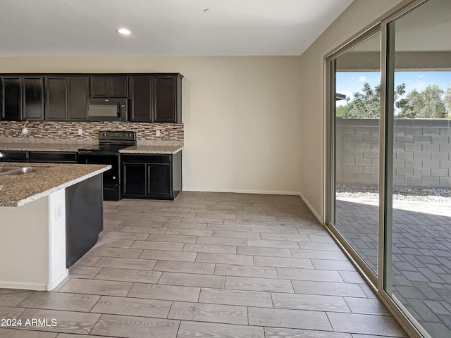 kitchen with light stone counters, decorative backsplash, and black appliances