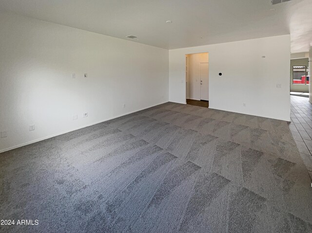 unfurnished room featuring dark carpet and visible vents