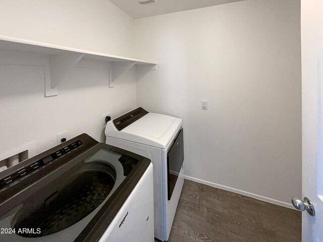 washroom featuring dark wood-type flooring and washer and clothes dryer