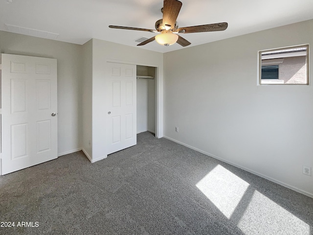 unfurnished bedroom with a closet, visible vents, dark carpet, a ceiling fan, and baseboards