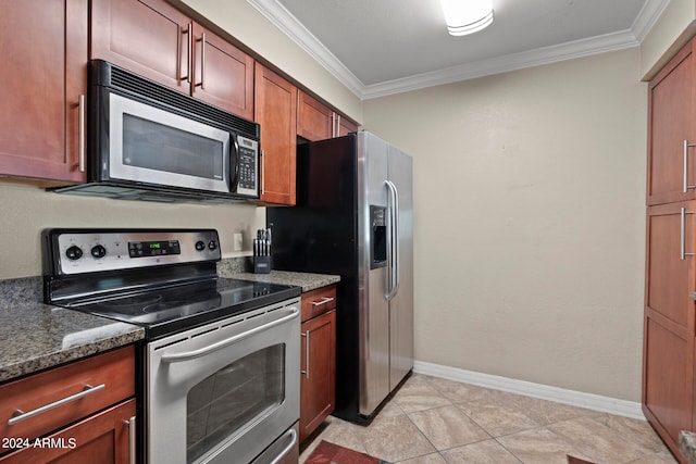 kitchen with dark stone counters, stainless steel appliances, light tile patterned floors, and crown molding